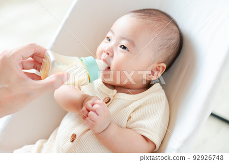 baby drinking milk deliciously 92926748