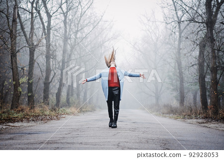 Alone Young woman with long fluttering hair express emotions in forest Alone Young woman with long fluttering hair express emotions in forest 92928053