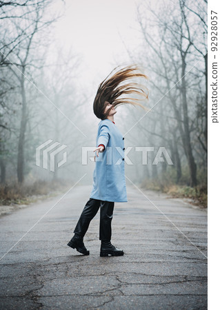 Alone Young woman with long fluttering hair express emotions in forest 92928057