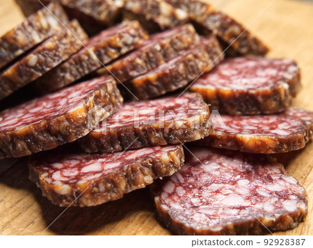 Meat appetizer. Dried sausage, macrophoto. Lots of sausage slices. Meat appetizer. Dried sausage, macrophoto. Lots of sausage slices. 92928387