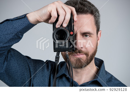Middle-aged photographer take photograph looking in eye of handheld photo camera, snapshot. Middle-aged photographer take photograph looking in eye of handheld photo camera, snapshot. 92929128