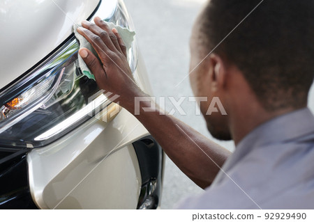 Taxi Driver Cleaning Car Headlights Taxi Driver Cleaning Car Headlights 92929490