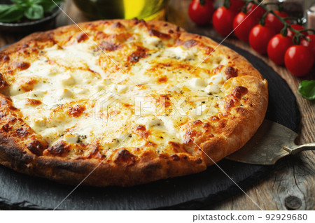 A slice of hot Italian pizza with stretching cheese. Pizza four cheeses with basil. 92929680