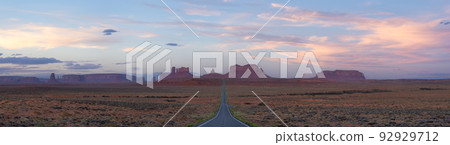 Scenic Road in the Dry Desert with Red Rocky Mountains in Background. 92929712