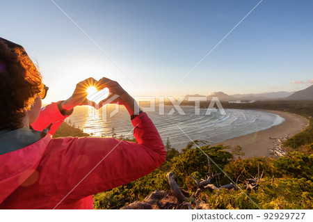 Adventurous Woman Hiker making heart shape with hands at Sandy Beach on the West Coast Adventurous Woman Hiker making heart shape with hands at Sandy Beach on the West Coast 92929727