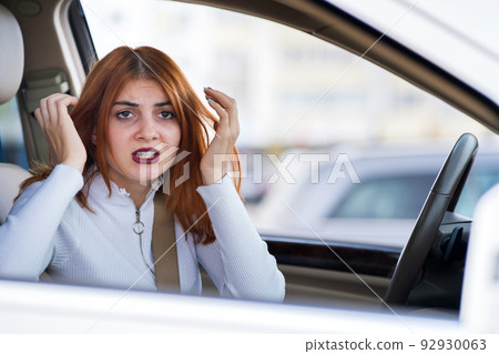 Closeup portrait of pissed off displeased angry aggressive woman driving a car shouting at someone. Negative human expression consept. 92930063