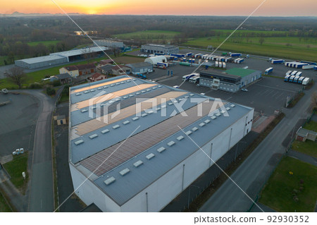 Aerial view of blue photovoltaic solar panels mounted on industrial building roof for producing green ecological electricity. Production of sustainable energy concept 92930352