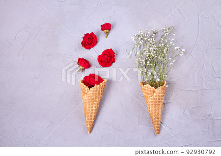 Two waffle ice cream cones with flowers. Top view flat lay. Two waffle ice cream cones with flowers. Top view flat lay. 92930792