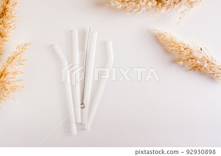 Glass reusable straws for drinks and cleaning brush on the table. Sustainable lifestyle. Top view Glass reusable straws for drinks and cleaning brush on the table. Sustainable lifestyle. Top view 92930898