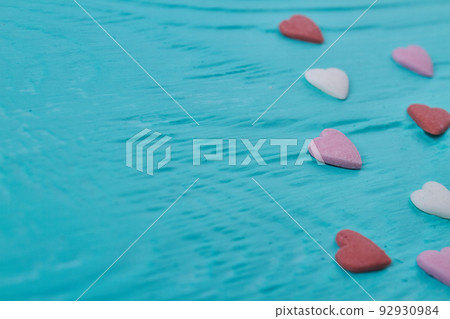 Close up colored candy hearts and copy space. Blue relief background. 92930984