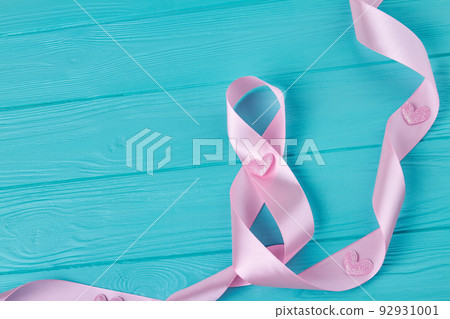 Pink ribbon tape on blue wooden desk. Happy women's day concept. Pink ribbon tape on blue wooden desk. Happy women's day concept. 92931001