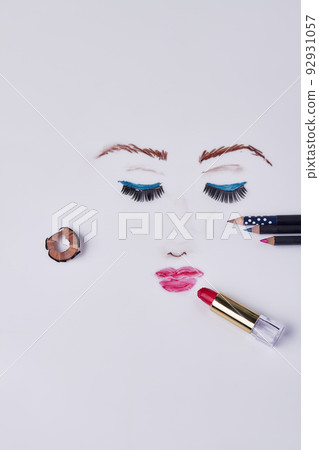Womans face drawn by makeup pencils and lipstick. Vertical shot white background. 92931057