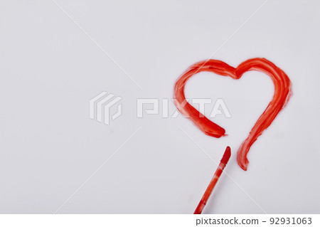 Red heart drawn by mascara on white surface. Valentines day concept. Red heart drawn by mascara on white surface. Valentines day concept. 92931063