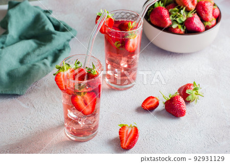 Two glasses with a strawberry cocktail and a bowl of berries on the table. Homemade drinks Two glasses with a strawberry cocktail and a bowl of berries on the table. Homemade drinks 92931129
