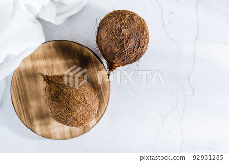 Two whole ripe coconuts on the table. Tropical fruits. Top view 92931285