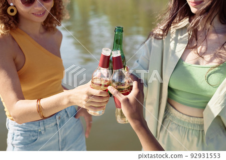 Friends Toasting with Beer Bottles Closeup Friends Toasting with Beer Bottles Closeup 92931553