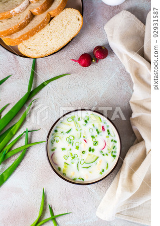 Appetizing traditional Russian cold soup with vegetables and kefir in a bowl. Top and vertical view Appetizing traditional Russian cold soup with vegetables and kefir in a bowl. Top and vertical view 92931587