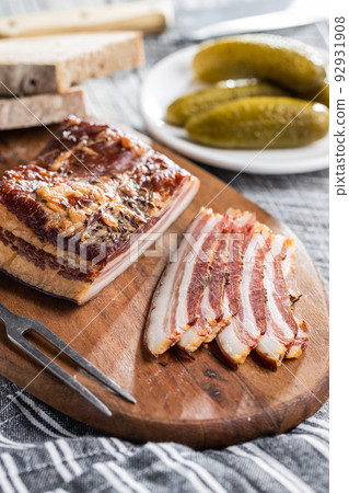 Sliced smoked bacon on cutting board. Sliced smoked bacon on cutting board. 92931908