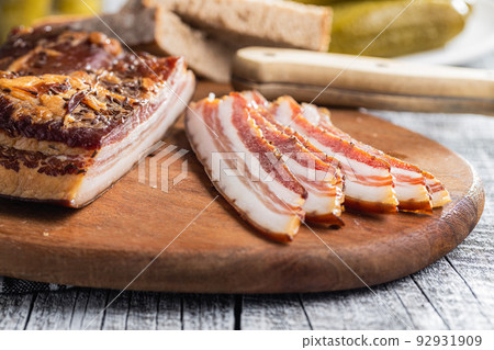 Sliced smoked bacon on cutting board. Sliced smoked bacon on cutting board. 92931909