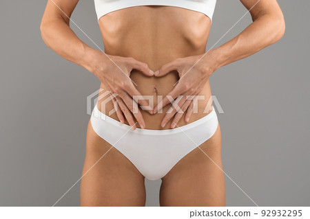 Bodycare. Slim Female In Underwear Making Heart Gesture With Hands Near Abdomen Bodycare. Slim Female In Underwear Making Heart Gesture With Hands Near Abdomen 92932295