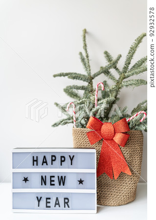 Happy New Year on vintage lightbox with New Years Eve decoration, concept image. Nobilis in a basket of candies. Happy New Year on vintage lightbox with New Years Eve decoration, concept image. Nobilis in a basket of candies. 92932578
