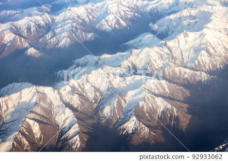 Aerial view on snowy mountais from airplan. 92933062