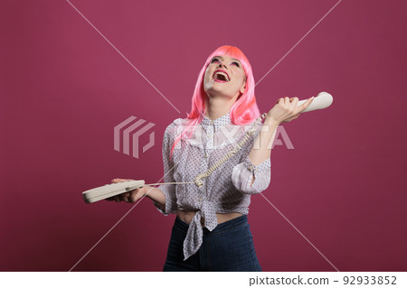 Portrait of trendy woman chatting on retro telephone line, feeling happy and excited talking on landline phone call. Remote conversation on stationary cord cellphone, vintage communication. 92933852