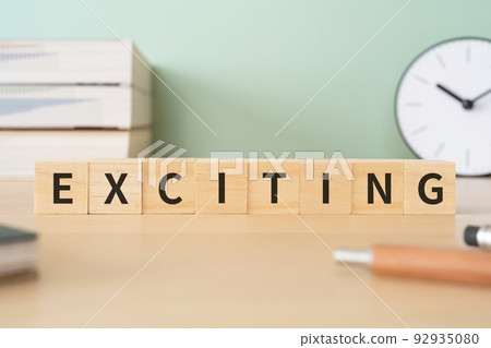 Image of excitement | A desk with a block written "EXCITING" 92935080