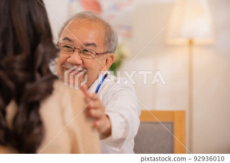 Senior Asian physician Watch as female patients discuss their health issues as you sit. Senior Asian physician Watch as female patients discuss their health issues as you sit. 92936010