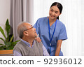 Happiness Cheerful elderly men talking with female caregiver nurse doctor having health checking consult at home. 92936012