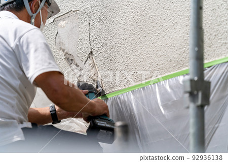 Construction site, exterior wall repair work, multi-tool Construction site, exterior wall repair work, multi-tool 92936138