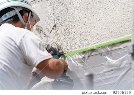 Construction site, exterior wall repair work, multi-tool Construction site, exterior wall repair work, multi-tool 92936139