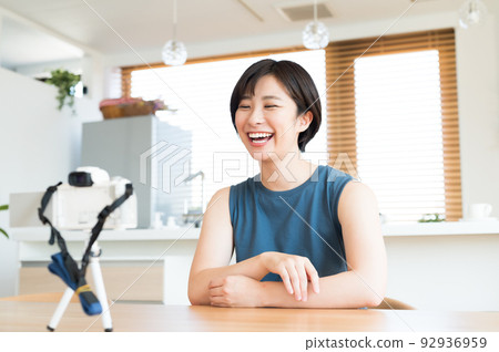 A woman recording a video in front of the camera 92936959