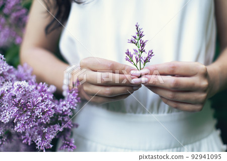 Hands of an attractive woman with a bouquet of lilacs. Spring and summer, seasonal photos. Front view. Hands of an attractive woman with a bouquet of lilacs. Spring and summer, seasonal photos. Front view. 92941095