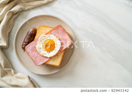 bread toasted cheese topped ham and fried egg with pork sausage 92943142