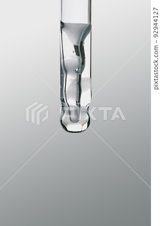 Pipette with gel cosmetic product on grey background, selective focus Pipette with gel cosmetic product on grey background, selective focus 92944127