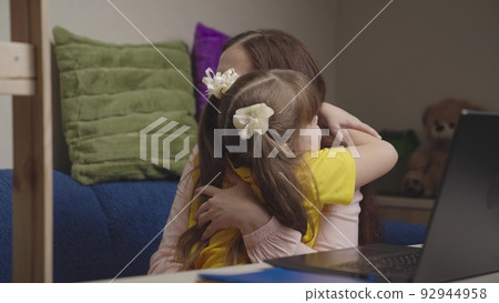 cheerful happy mom with child doing homework laptop. american education online. teamwork. happy family. child kid daughter hugs parent mother. together win going to success. maternal care love kid. 92944958