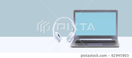 Laptop with wireless headphones on white desk Laptop with wireless headphones on white desk 92945903