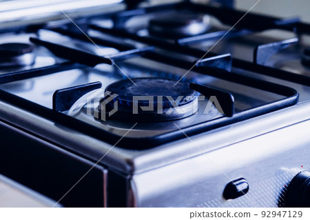 Kitchen gas hob, stove cook with blue flames burning 92947129