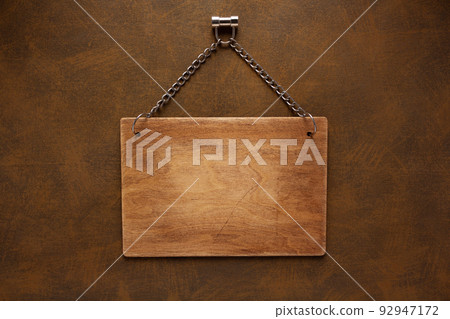 Wooden nameplate or sign board at wall background. Front view of name plate 92947172