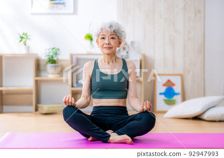 Senior woman doing yoga at home 92947993