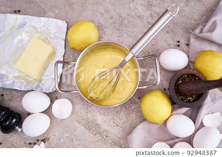 making traditional hollandaise sauce in a pot at domestic kitchen 92948387