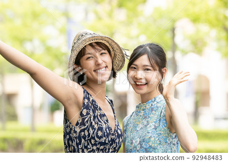 Two young women in dresses enjoying a girls' trip/resort trip 92948483