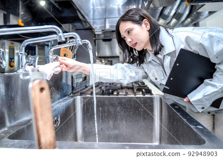 檢查廚房的年輕女子，商用不銹鋼水槽，商用水槽 92948903