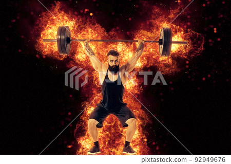 Portrait of an athlete who is lifting the barbell in the gym. The concept of sport and healthy lifestyle. Mixed media 92949676