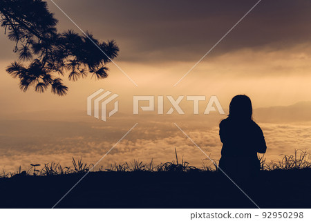 A woman sitting and waiting sunrise over Phu Kradueng national park one of the most popular national parks in Loei province of Thailand. 92950298