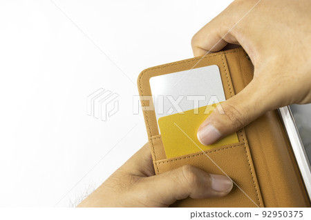 一個男人的手從智能手機外殼中取出信用卡 一個男人的手從智能手機外殼中取出信用卡 92950375