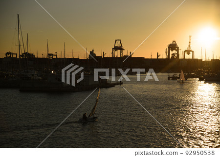 Sailboat on sunset in harbour. Sailing on sea on sailboat on the waves. 92950538