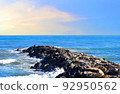 Breakwater with waves in sea. Waves at the stone pier. 92950562