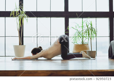 Meditation during pregnancy. Young calm tranquil pregnant woman doing yoga at home, meditating and practicing mindfulness Meditation during pregnancy. Young calm tranquil pregnant woman doing yoga at home, meditating and practicing mindfulness 92950723